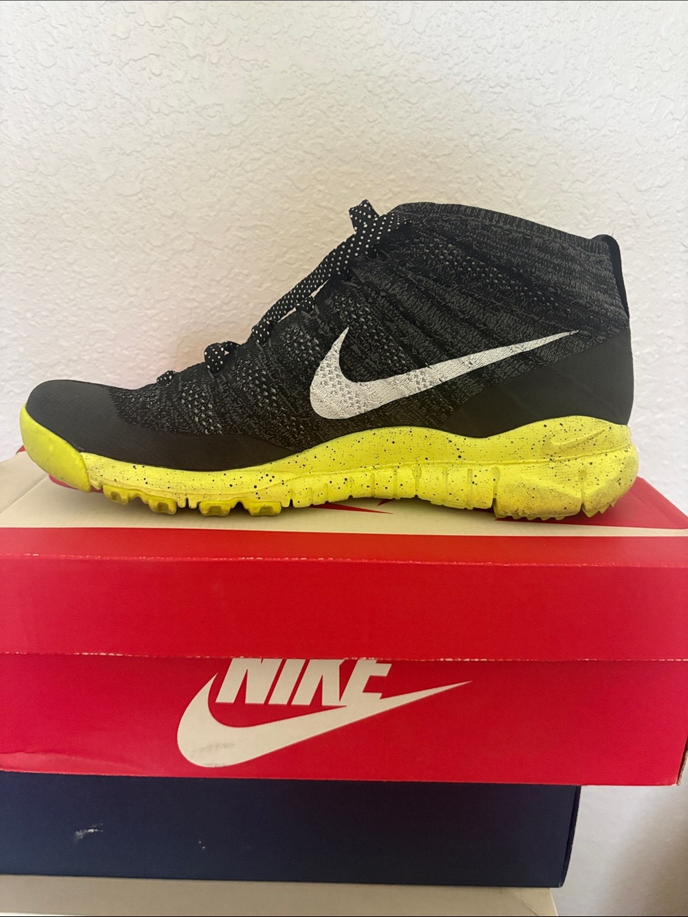 Nike Black Flyknit Mid-Top Sneaker with White Swoosh and Yellow Sole